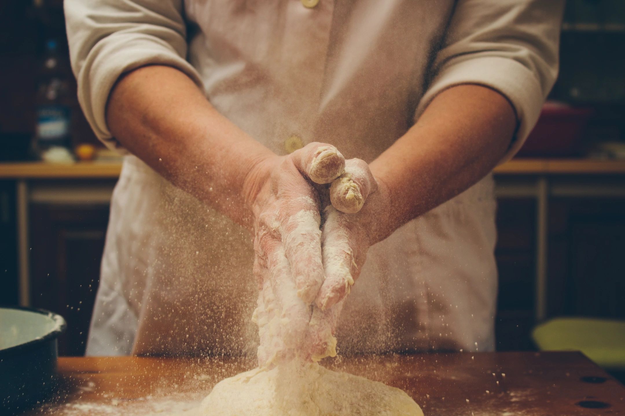 Baker kneading dough with flour